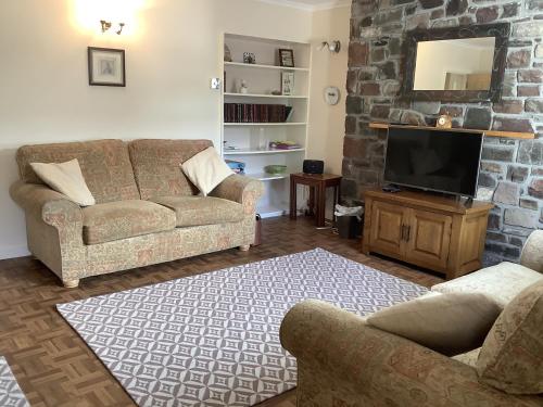 a living room with two couches and a tv at Moriston Cottage in Lochcarron
