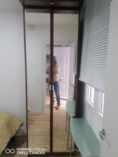 osoba robiąca zdjęcie lustra w pokoju w obiekcie Apartamento B-2 w Madrycie