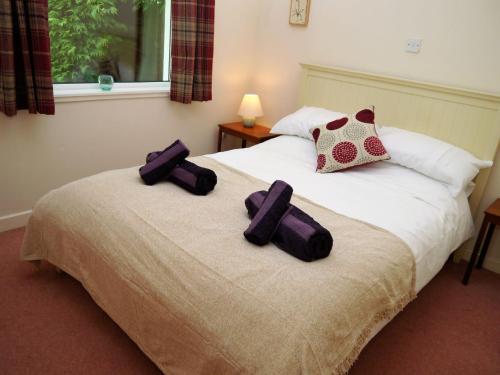 a bedroom with a bed with two crosses on it at Moriston Cottage in Lochcarron