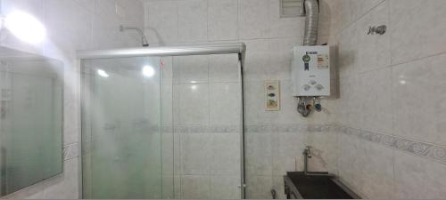 y baño con ducha y puerta de cristal. en Prado Junior Apartament, en Río de Janeiro