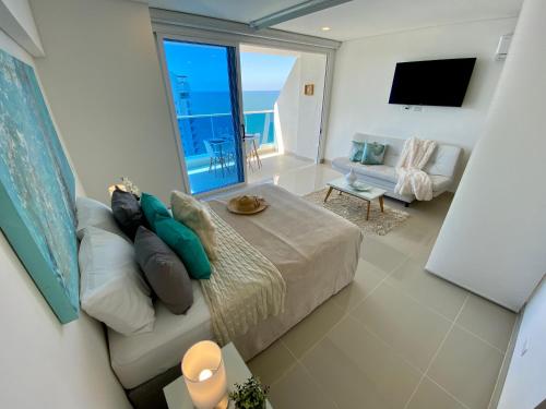 sala de estar con sofá y vistas al océano en Apartamentos Reserva del Mar - Frente al Mar by SOHO, en Santa Marta