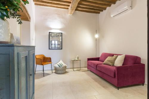 a living room with a purple couch and a chair at Bolgheri Bramasole in Bolgheri