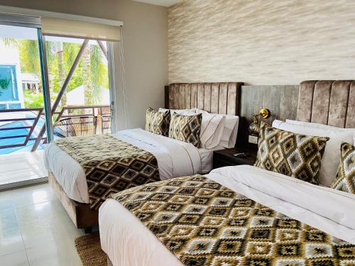 a hotel room with two beds and a balcony at AITABU HOTEL CAMPESTRE in Villavicencio