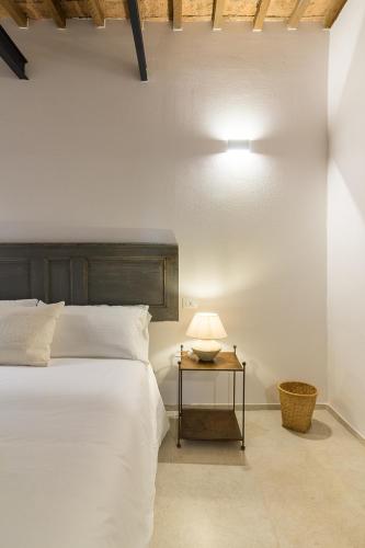 a bedroom with a bed and a table with a lamp at Bolgheri Bramasole in Bolgheri