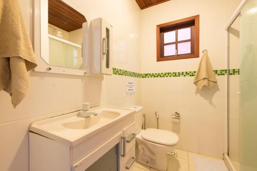 Baño blanco con lavabo y aseo en Meu Sonho Búzios, en Búzios