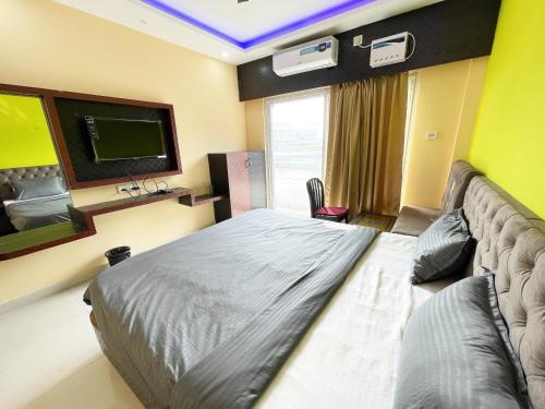 a bedroom with a bed and a flat screen tv at ojotrip Hotel Basanti INN- puri in Puri