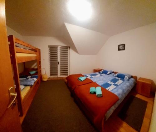 een slaapkamer met 2 bedden en een stapelbed bij Guesthouse Kusić in Kupres