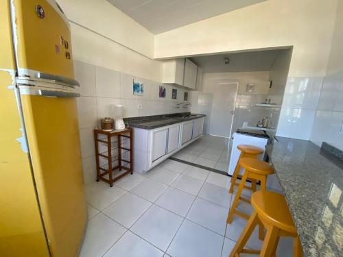 a kitchen with a counter and two stools in it at Beach House Peroba in Maragogi
