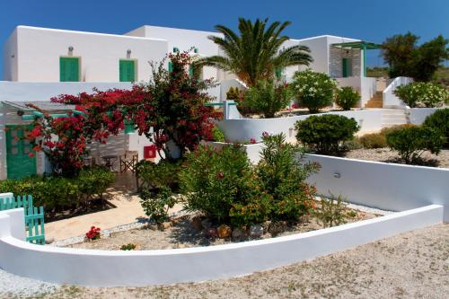 a garden in front of a white building with flowers at Psilandis Studios in Adamas