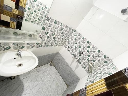 ein Bad mit einem Waschbecken und einem Spiegel in der Unterkunft ojotrip Hotel Basanti INN- puri in Puri