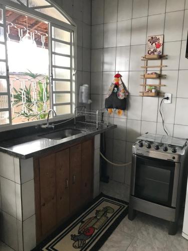 a kitchen with a sink and a stove at Pousada da Benção in Cachoeira Paulista