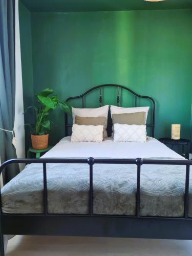- une chambre dotée d'un lit avec un mur vert dans l'établissement Bel appartement à 3 min de la plage de 60m², à Saint-Nazaire