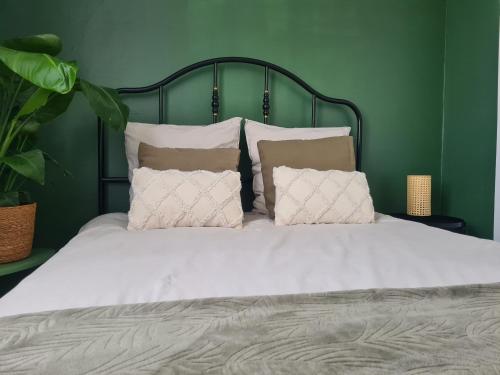 uma cama grande com lençóis brancos e almofadas em Bel appartement à 3 min de la plage de 60m² em Saint-Nazaire