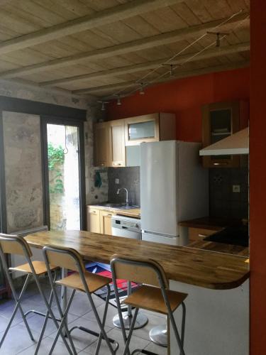 une cuisine avec une table et des chaises en bois dans l'établissement Petite maison sur jardin secret, à Avignon