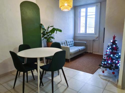 un salon avec une table et un sapin de Noël dans l'établissement Bel appartement à 3 min de la plage de 60m², à Saint-Nazaire