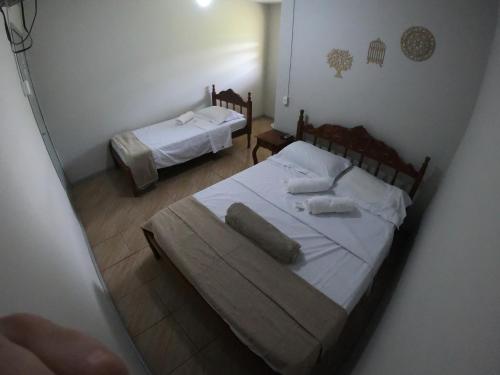 a bedroom with two beds with white sheets at Pousada Solar da Montanha in Pedreira
