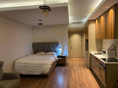 1 dormitorio con 1 cama y cocina con microondas en Low Price Luxury Apartment Perfect for An Amazing Stay, en Estambul