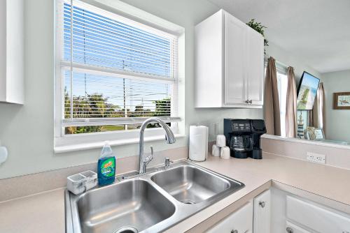 a kitchen with a sink and a window at Beachside Serenity Escape - Private 3BR and 2BA, DOG FRIENDLY Duplex Oasis, Steps to Shore! in Melbourne