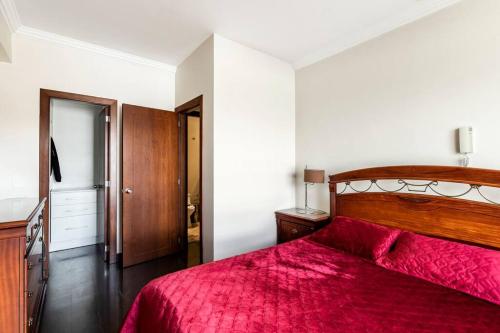 1 dormitorio con 1 cama con edredón rojo en MINI APARTAMENTO, Netflix, Disney Plus, sector privilegiado, cerca de todo, en Quito