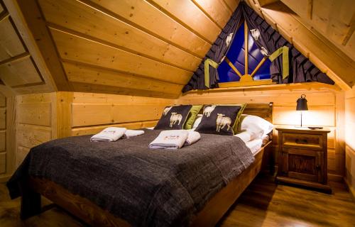 une chambre avec un lit dans une cabane en rondins dans l'établissement Myśliwski Domek pod Giewontem, à Zakopane