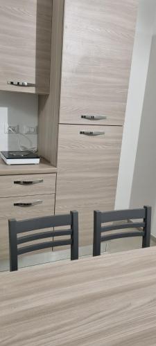a kitchen with two chairs and a table and cabinets at Farolfi Apartments Galliera Rooms & Apartments in Bologna