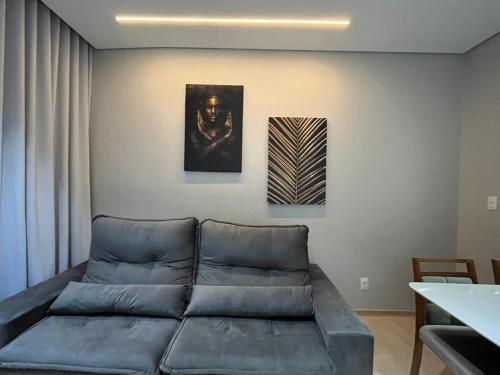 a living room with a couch and a painting on the wall at Diamond é o seu lugar ! in Belo Horizonte