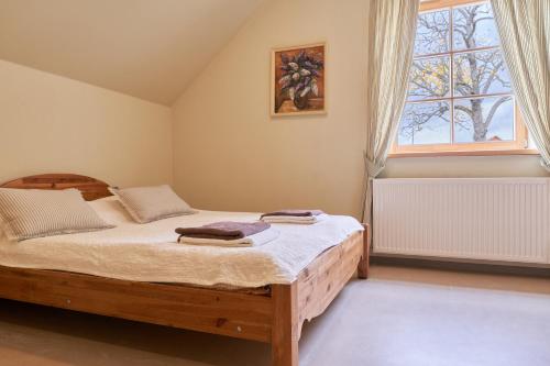 a bedroom with a large bed and a window at Juku Dzirnavas in Zutēni