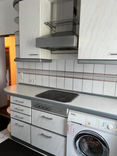 a kitchen with a stove and a washing machine at Pension Rüge in Frankfurt