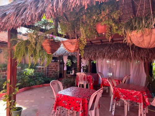 a restaurant with tables and chairs with red table cloth at Pousada Vitória do Lopes in Barreirinhas