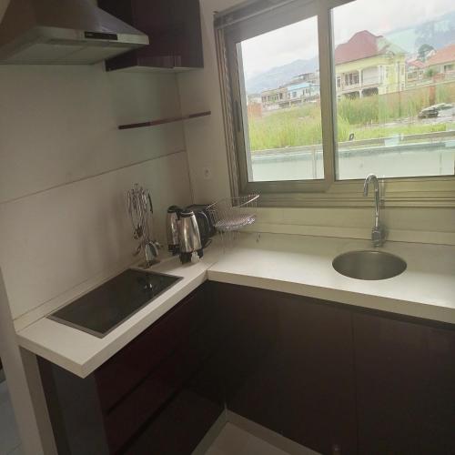 a kitchen with a sink and a window at Paradise Appartment hotel in Mutumba
