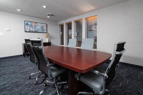 a conference room with a wooden table and chairs at Endeavor Inn & Suites, Trademark Collection by Wyndham in Topeka