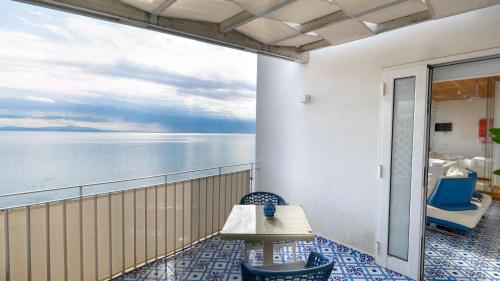 a balcony with a table and chairs and the ocean at Aquaboutique Wellness&Spa in Vietri sul Mare
