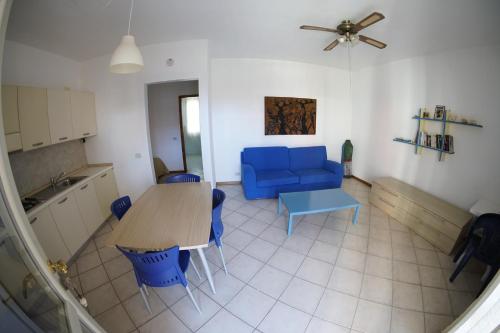 uma sala de estar com uma mesa e um sofá azul em Estoril Hotel - Apartments em Sal Rei