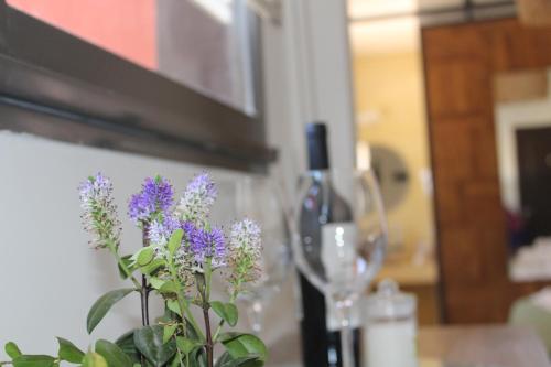 a bottle of wine and a plant with purple flowers at ESPACIO RAKU in Ciudad Lujan de Cuyo