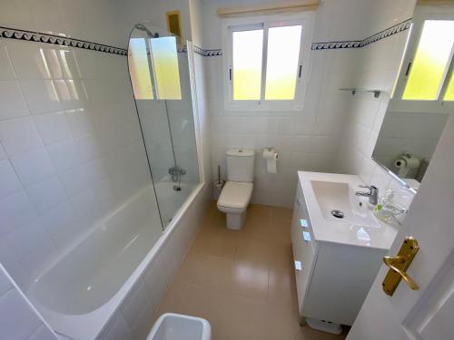 ein weißes Badezimmer mit einer Badewanne, einem WC und einem Waschbecken in der Unterkunft Apartamento con gran terraza and view in Marbella