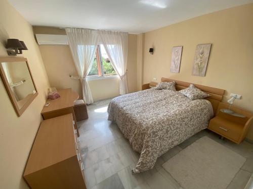 ein Schlafzimmer mit einem Bett, einer Kommode und einem Fenster in der Unterkunft Apartamento con gran terraza and view in Marbella