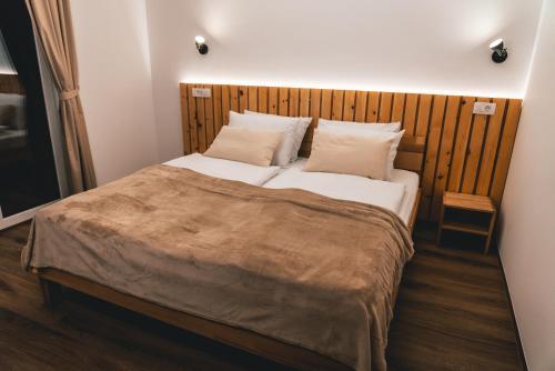 una camera con un grande letto con testiera in legno di Podlipnik Apartments a Rateče