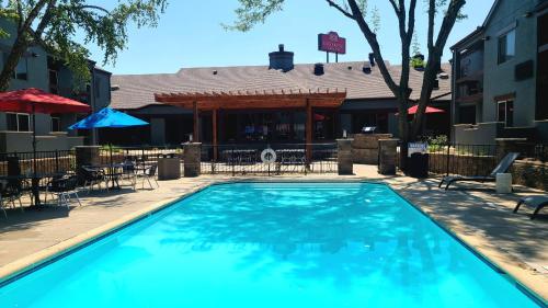 a large swimming pool in front of a restaurant at Endeavor Inn & Suites, Trademark Collection by Wyndham in Topeka