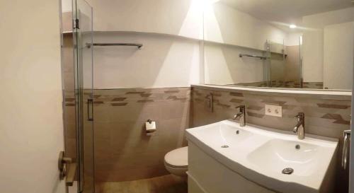 La salle de bains est pourvue d'un lavabo, de toilettes et d'un miroir. dans l'établissement EL BOBO BEACH- Deluxe 2 bedroom apartment, à Playa de Fañabé