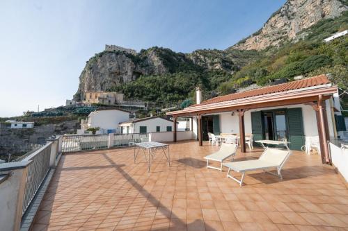 a house with a balcony with a table and chairs at Il Rifugio Del Merlo in Amalfi