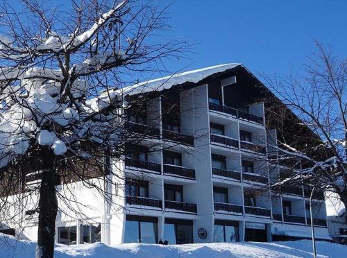 a large white building with snow on it at Apartmány Almberg in Philippsreut