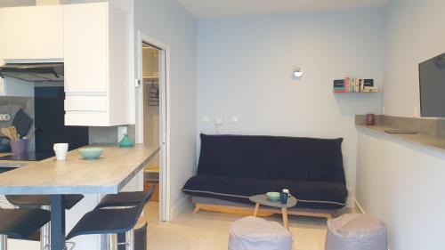 un salon avec un canapé bleu dans une cuisine dans l'établissement Studio Corsaire 4J, à Granville
