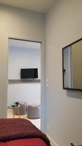 une chambre avec un lit et une télévision à écran plat dans l'établissement Studio Corsaire 4J, à Granville