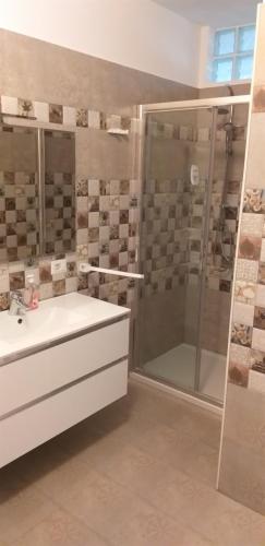 a bathroom with a white sink and a shower at APARTAMENT BELUX in Eforie Sud