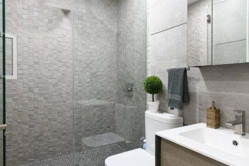 ein Bad mit einer Dusche, einem WC und einem Waschbecken in der Unterkunft 75-2B Prime Upper East Brand New 1BR W D Elev in New York