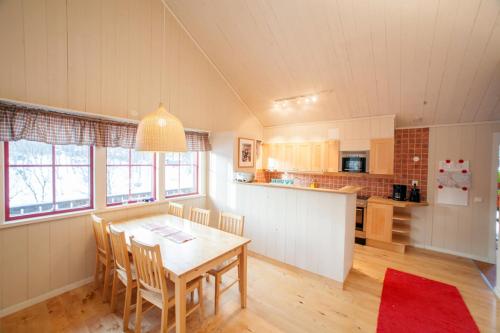 a kitchen and dining room with a table and chairs at Bruksvallarna Lullens stugby in Bruksvallarna