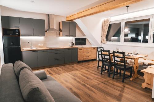 uma cozinha e sala de jantar com um sofá e uma mesa em Podlipnik Apartments em Rateče
