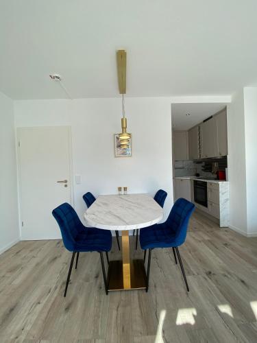 a dining room with a table and blue chairs at Modernes Apartment an Timmendorfer Promenade, 1. Reihe in Timmendorfer Strand