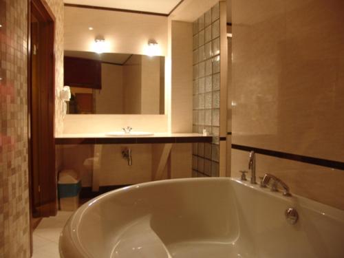 baño con bañera grande y lavamanos en Motel Delfin ** en Trojanów