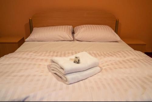 a bed with towels and a stuffed animal on it at Motel Delfin ** in Trojanów